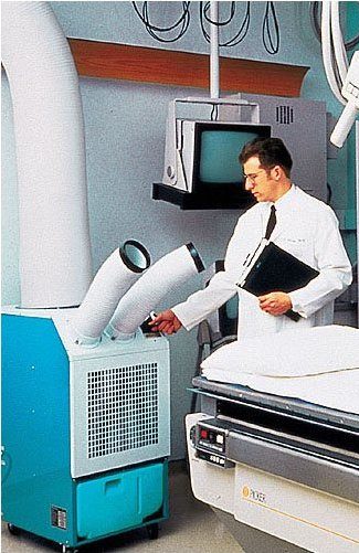 A doctor checking the settings on a Portable Air Group portable air conditioner